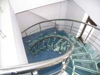 экспонентная лестница со стеклянными ступенями и ограждением  из нержавеющей стали